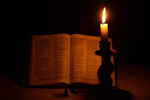 Open Bible with evening candle light representing a Christian night routine for anxiety and stress